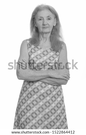 Studio shot of senior woman with arms crossed