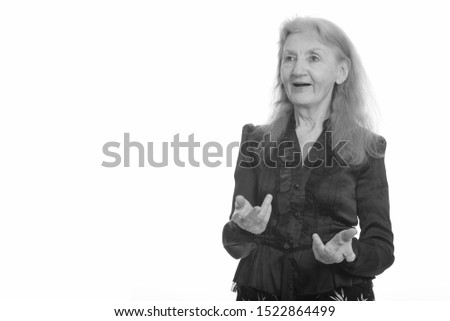Studio shot of senior businesswoman explaining in black and white