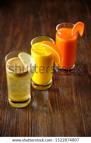 Multi-colored shots with fruit slices on a dark wooden background. catering menu