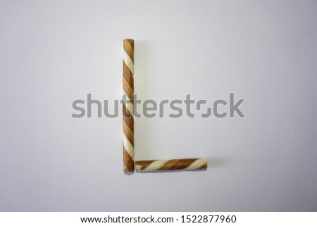 An alphabet letter from a brown wafer stick with a white background.
