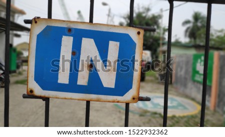 in/entrance sign hangging on the fence