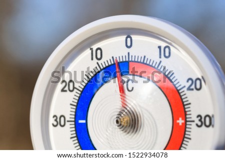 Outdoor thermometer with Celsius scale showing cold minus 4 degrees temperature - dramatic weather change or cold wave concept Royalty-Free Stock Photo #1522934078