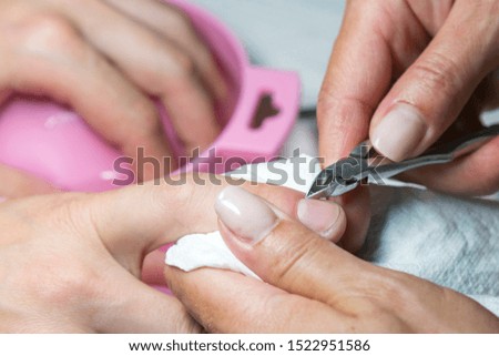 Woman hands receiving manicure and nail care procedure. Close up concept. Manicurist pushing cuticles on female's nails. female nail manicure processing