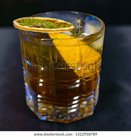 Cocktail with lemon. In a simple glass. On a dark background.