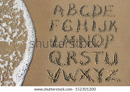 Alphabet letters handwritten in sand on beach Royalty-Free Stock Photo #152301200