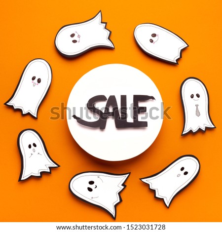 Horrible Halloween sales text in frame surrounded by whispering ghosts on orange background