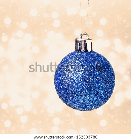 Christmas card with blue hanging ball  on Defocused gold Christmas Bokeh  like champagne splashes. Christmas background. High Resolution.