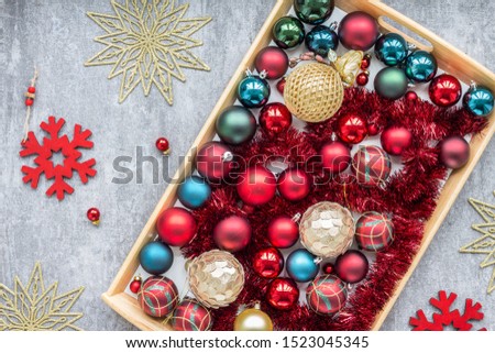 Christmas decoration, gold, red, green balls, snowflake on dark grey background, top view, flat lay