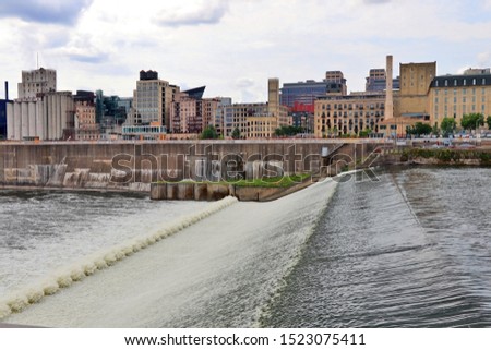 Urban cityscape and modern architecture background. Dramatic cloudy sky over Minneapolis downtown and Mississippi river with Saint Anthony Falls. Midwest USA, Minnesota.