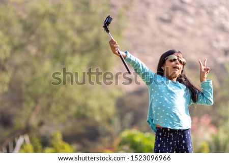 Little girl taking a picture with an action camera