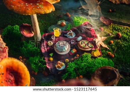 Picnic under toadstool mushroom, miniature food in the forest, tiny world concept. Magical art photo header.