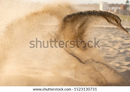 Throwing sand, forming the figure of a snake or a bird.