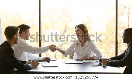 Confident smiling female company owner executive manager shaking hands with corporate clients after successful negotiations. Happy woman representative welcoming investors at office business meeting. Royalty-Free Stock Photo #1523265974