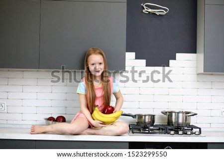little girl in the kitchen posing at the camera
