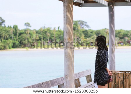 A woman standing and looking at the sea and nature