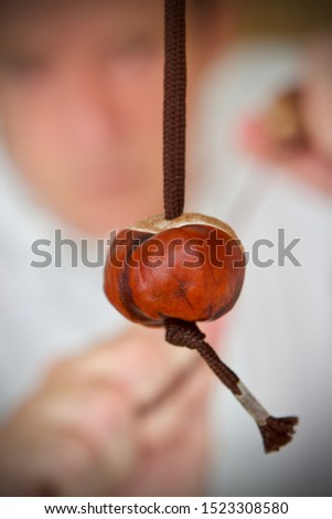 Caucasian teenage boy playing a game of conkers