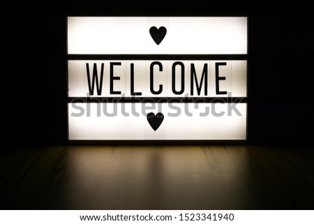 Light box with the word "welcome". Dark background.