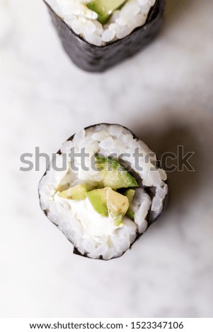 rolls with avacdo and sticks on a marble background