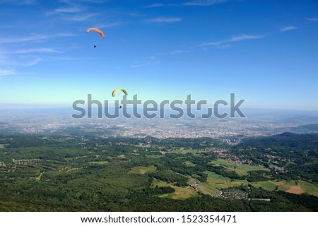 Paragliders in full flight over volcanoes of Puy de Dome in the central massif near Clermont-Ferrand Royalty-Free Stock Photo #1523354471