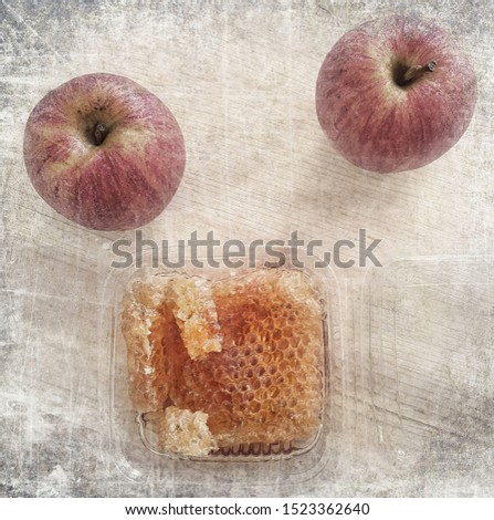 Old paper texture with red apples and honey in honeycomb and. Sweet lovely gift. Photo image done in retro card style            