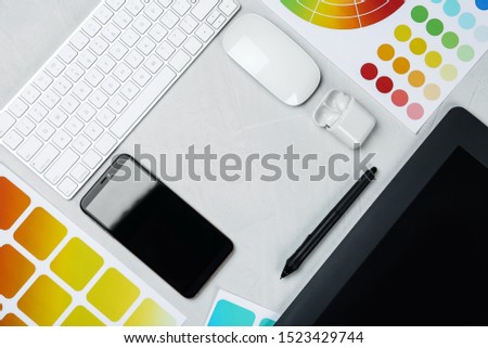 Flat lay composition with digital devices and color palettes on white background, space for text. Graphic designer's workplace