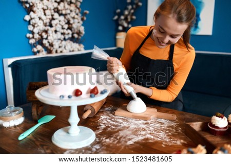 cheerful confectioner enjoying cooking muffins at home, pastime, job, profession