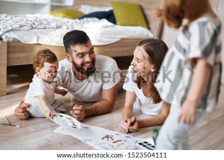 young pleasant parents laughing, enjoying time with children at home. close up photo