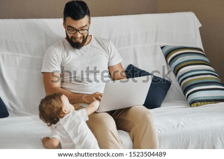 little adorable child helping his father to work on laptop. close up photo. free time, spare time, lifestyle
