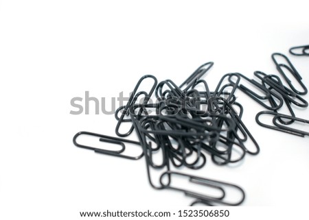 Clip for office accessories. Stationery. Black clips in a chaotic order. On a white background.