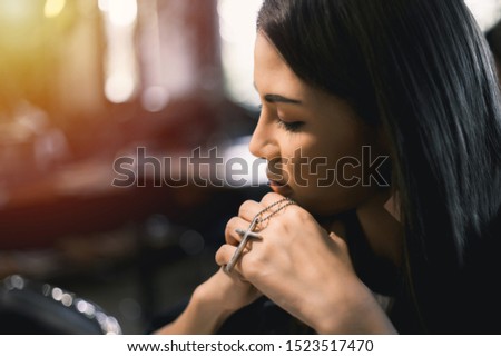 Closeup picture of woman christian. Her hands and pray for God to bless the cross pendant. Concept of religion and belief