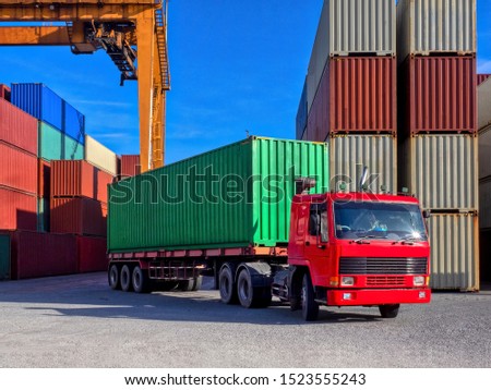 The RTG(Rubber Tried Gantry Cranes) pick up full loaded containers on truck at container yard  and delivery to customers. Royalty-Free Stock Photo #1523555243