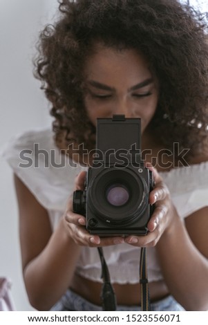Good-looking young woman holding her professional camera