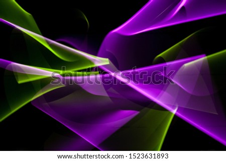 Light painting abstract background. Violet and green light painting photography, long exposure, ripples and swirl against a black background. 