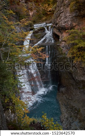 The waterfall of the Cave and the beech forest with its fall colors in the National Park of Ordesa and Monte Perdido. Huesca. Aragon. Spain.
