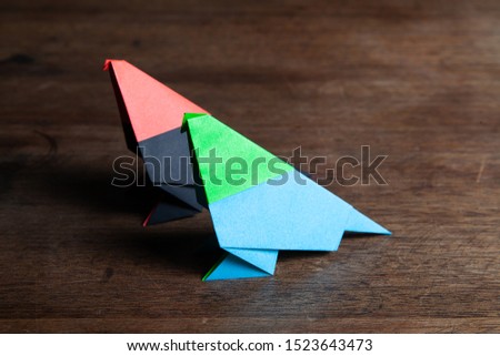 A cute colored origami birds on a rustic wooden surface. 