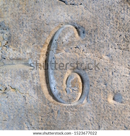 Number six (6) engraved in stone