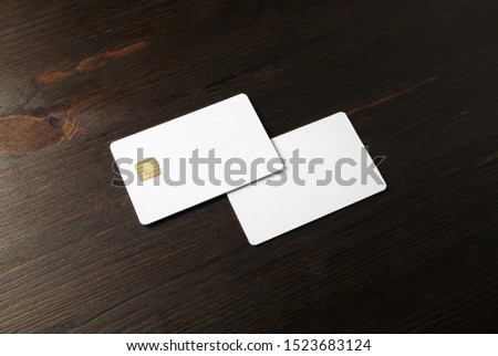 Two blank credit cards on wooden background. Photo of white bank cards. Mockup for branding identity.