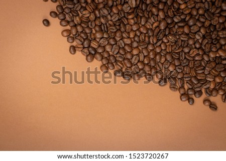 Dark whole coffee beans on brown background with copyspace. Roasted coffe grains for menu, banner template, wallpaper or recipe image design