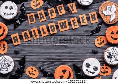 Happy Halloween background, homemade funny spooky scary cookies pumpkins bats and spiders web on brown wooden table, handmade sweets on trick or treat holiday decoration, top view above, copy space