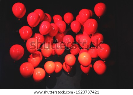 Bright and shiny red balloons inflatable up with black background. Black friday poster. Christimas wallpaper. Birthday balloons.
