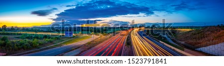 Colorful sunset at M1 motorway near Flitwick junction with cars light trails. United Kingdom Royalty-Free Stock Photo #1523791841