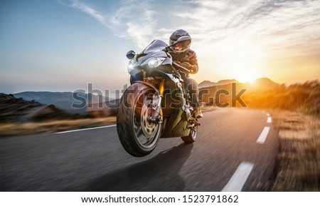 Fast Motorcycle on the coast road riding. having fun driving the empty highway on a motorbike tour journey. copyspace for your individual text. Royalty-Free Stock Photo #1523791862