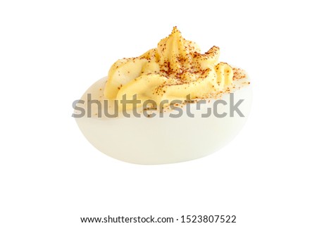 A deviled egg halves sprinkled with paprika and isolated over a white background. Clipping path included.