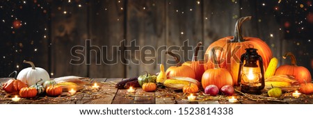 Wooden Table With Lantern And Candles Decorated With Pumpkins, Corncobs, Apples And Gourds With Wooden Background - Thanksgiving / Harvest Concept
