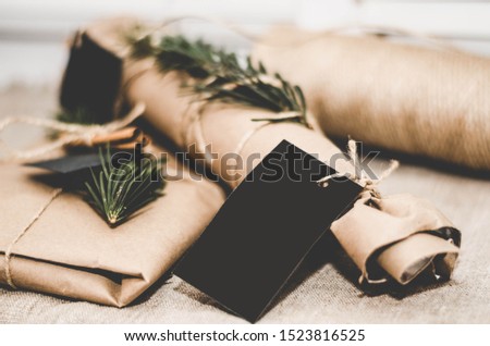 Christmas gift in Kraft paper with label for inscription with cinnamon and spruce branch