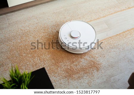 Robot vacuum cleaner performs automatic cleaning of the apartment at a certain time. Smart home. Royalty-Free Stock Photo #1523817797