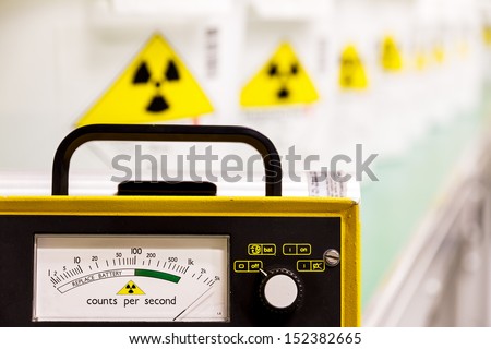 Geiger counter with radioactive materials in the background