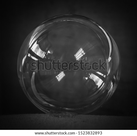 A digitally enhanced, close-up photograph of a soap bubble with an added monochromatic filter for artistic effect. 