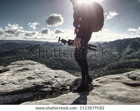 Professional nature photographer or cameraman setting tripod before shooting 