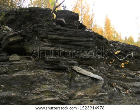 Russia. Sverdlovsk region. Pervouralsk. Photo of a view of the Dinasovsky quarry flooded with blue water on Mount Karaulnaya. Autumn landscape with trees with yellow leaves on the rocks.